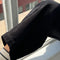 up close of model wearing black corduroy arc pants with side panels and pockets