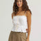 model wearing white cami tank with ruffle trim, button front and tie waist