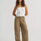 model wearing tan brown slouch chino pants with pleated front