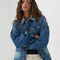 model wearing patched denim chore jacket with a mix of light and dark wash denim and front patch pockets