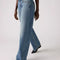 side view of model wearing light denim low loose jeans