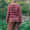 back view of model wearing textured cardigan with red and pink horizontal stripes