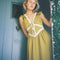 model wearing chartreuse midi dress with white lace accents on the bust, two tie front and ruffle detail on the shoulders