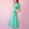 side view of model wearing green puff sleeve v-neck midi dress with pale yellow ruffle under the bust