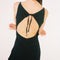 back view of model wearing black crinkle maxi dress with asymmetrical hem and open back