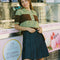 model wearing brown and mint striped short sleeve polo sweater