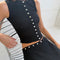sideview of model wearing black crinkle midi skirt with shaped shell buttons on the top and matching tank