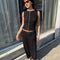 model wearing black crinkle midi skirt with shaped shell buttons on the top and matching tank