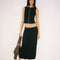 model wearing black crinkle midi skirt with shaped shell buttons on the top and matching tank