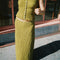 model wearing olive crinkle midi skirt with shaped shell buttons on the top and matching tank