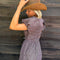 model wearing brown striped midi dress with puff sleeves, v-waistline and tie back