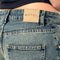 up close of back of blueish-green low rise wide leg denim