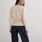 back view of model wearing ivory cardigan with cinched in waist