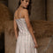back view of model wearing light pink tank with side corset ties and vintage dainty floral wallpaper print