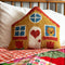 yellow house shaped throw pillow on a bed