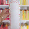 model holding light blue and white vertical stripe with cherry print and shopping list with lines
