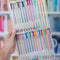 model holding opened set of 30 glitter, metallic, pastel, neon and primary gel pens