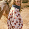 side view of model wearing white sherpa half zip with denim trim and collar and red floral print