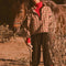 model wearing tan fleece half zip sweatshirt with red floral print and black piping on the arms and zipper