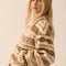 side view of model wearing cropped white zip up jacket with brown alpine print