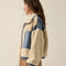 side view of model wearing cream sherpa zip-up jacket with blue denim trim with a high neck collar