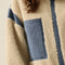 up close of model wearing cream sherpa zip-up jacket with blue denim trim with a high neck collar