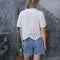 back view of model wearing white scalloped hem blouse with slight puff sleeves and faux button front