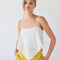 model wearing white handkerchief tank with eyelet floral detail and tie detail