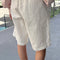 back view of model wearing white cotton relaxed fit bermuda shorts