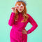 model wearing pink pastel sunglasses with pink lens and pink tree with pom details on top