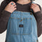 up close of model wearing stonewash relaxed fit overalls with multiple pockets and 'carpenter' type style