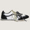 side view of black and metallic silver super low pro sneakers with black and white speckled laces and sage laces