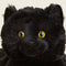 up close of black cat with yellow eyes warmie plush