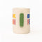 side view of cream ceramic coffee mug with green handle and colorful 'book person' across the front and smiley face inside