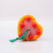 top view of ceramic pink cake shaped ornament with orange and white trim and 'cherries on top'