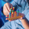 Person in blue jumpsuit holding the peg game in the foreground
