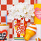 Red and white popcorn bag vase with white flowers