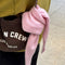 light pink bandana on a purse