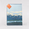back view of passport holder with colorful mountain scene and 'greeting from paradise' across the front