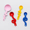 set of 4 stainless steel measuring spoons in pink, red, yellow and blue with squiggle handle