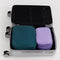 set of packing cubes: medium lavender and large navy in a suitcase