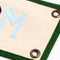 up close of grommets on canvas banner with rainbow 'bookworm' across the front and kelly green border