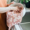 model using pink tea towel to dry a bowl