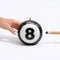 lit 8-ball candle with pool stick and hand