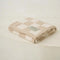 folded cream and khaki checkered blanket