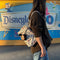 model carrying cream bowler bag with mickey and minnie head print surrounded by dainty floral