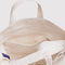 interior of tan horizontal zip bag with teddy bear with a red bow around the neck