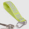 up close of lime green keychain with grey 'baggu' logo and carabiner clip
