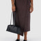 model holding medium black recycled dome bowler bag with silver charm clasp
