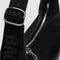 up close of silver buckle on small black recycled leather crescent bag with monochromatic strap